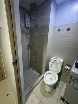 a small bathroom with a toilet and a shower at Cozy home in Manila