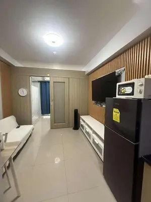a living room with a couch and a tv in a room at Cozy home in Manila