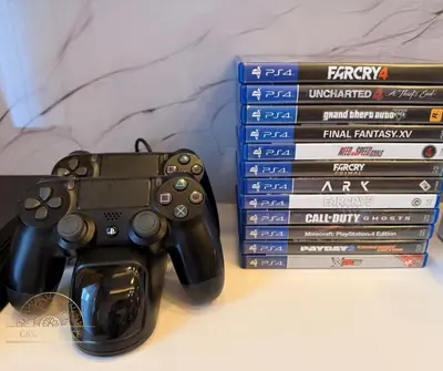 a video game controller sitting next to a stack of dvds at 2BR Luxe Staycation in Charm Residences in Manila