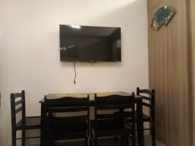 a dining room table with chairs and a television on the wall at Shore Residence Tower C2 in Manila