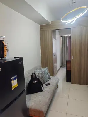 a living room with a couch with a bag on it at AHD Staycation in Manila