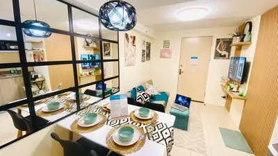 a living room with a table and chairs in a room at 1Haven in Pasig CCF Bridgetown in Manila