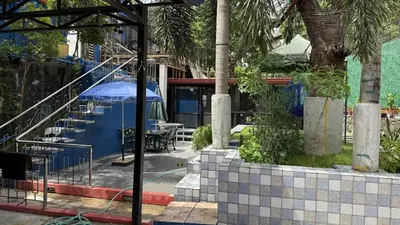 a patio with a table and a blue umbrella at Noirescape in Binangonan