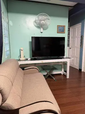 a living room with a couch and a flat screen tv at Noirescape in Binangonan