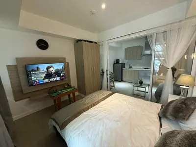 a bedroom with a bed and a flat screen tv at AZURE BICUTAN POSITANO Tower in Manila