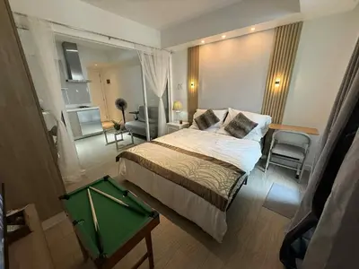 a hotel room with a bed and a green table at AZURE BICUTAN POSITANO Tower in Manila