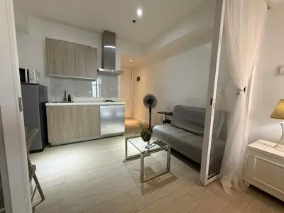 a living room with a couch and a kitchen at AZURE BICUTAN POSITANO Tower in Manila