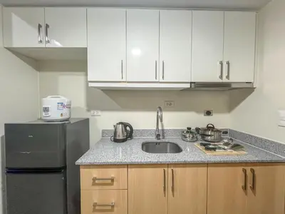 a kitchen with a sink and a refrigerator at DH Suites in Manila