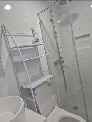 a ladder above a toilet in a bathroom at Modern Minimalist 1BR Condotel at BGC Taguig in Taguig