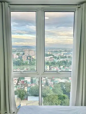 a bedroom window with a view of a city at Comfy Spot Staycation Studio at Kasara Urban Pasig in Manila