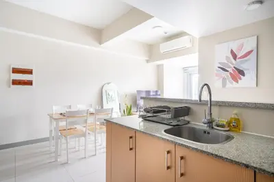 a kitchen with a sink and a counter top at Uptown Parksuites BGC Stylish 2BR Fast WiFi Washer Balcony in Manila