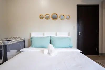 a bedroom with a bed with two towels on it at Uptown Parksuites BGC Stylish 2BR Fast WiFi Washer Balcony in Manila