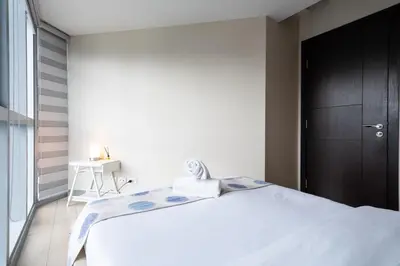 a bedroom with a large white bed and a black door at Uptown Parksuites BGC Stylish 2BR Fast WiFi Washer Balcony in Manila
