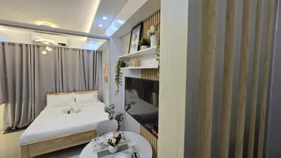 a small bedroom with a bed and a table at Sheena's Suite by Staycation in Manila