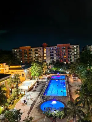 a view of a swimming pool at night at 1BR Cozy Home with Balcony Near NAIA Terminals in Manila