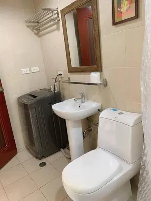 a bathroom with a white toilet and a sink at Modern Makati Condo for Rent - City Views Convenience in Manila