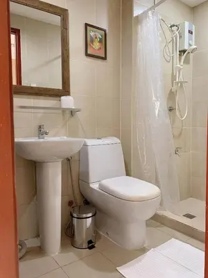 a bathroom with a toilet and a sink and a shower at Modern Makati Condo for Rent - City Views Convenience in Manila