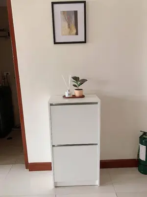 a white cabinet with a plant on top of it at Modern Makati Condo for Rent - City Views Convenience in Manila