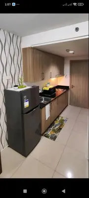 a kitchen with a black refrigerator and a counter at All I Want Relax at Shore Residences in MOA Complex in Manila