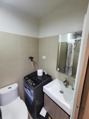 a bathroom with a white toilet and a sink at Mall of Asia Staycation shore 3 in Manila