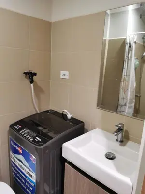 a bathroom with a sink and a trash can and a mirror at Mall of Asia Staycation shore 3 in Manila
