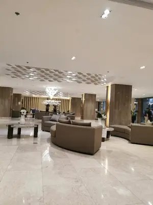 a lobby with couches and tables in a building at Mall of Asia Staycation shore 3 in Manila