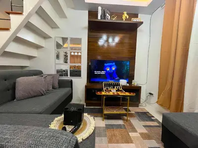 a living room with a couch and a tv at Balai Sais - Your Scenic Home Away from Home! in Binangonan