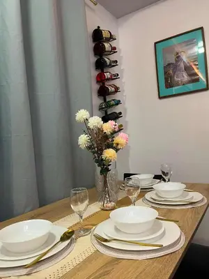 a table with plates and glasses and a vase with flowers at Balai Sais - Your Scenic Home Away from Home! in Binangonan