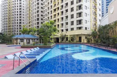 a large swimming pool in a city with tall buildings at 1 BR Central and Cozy Condo Prime Location in BGC in Manila