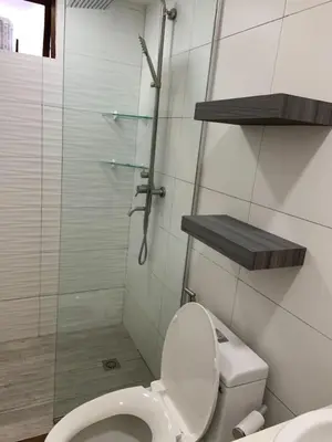 a bathroom with a toilet and a glass shower at Comfy and Renovated 1 BR with Balcony BGC Golf View in Manila