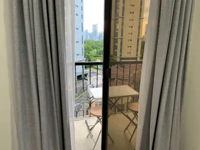 a view from a window of a balcony with a table and chairs at Comfy and Renovated 1 BR with Balcony BGC Golf View in Manila