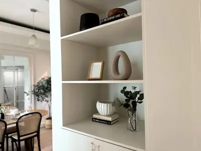a room with a table and a shelf with a vase at Modern Luxe 3 BR Home BGC in Manila