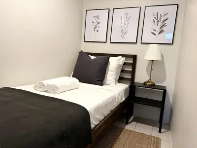 a bedroom with a bed and a lamp and pictures at Modern Luxe 3 BR Home BGC in Manila