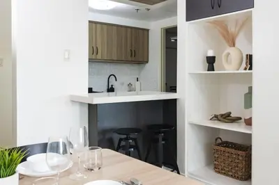 a kitchen with a table with wine glasses on it at Scandi 1 BR Home Golf View BGC in Manila