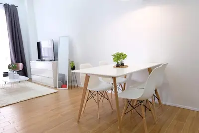 a dining room with a white table and white chairs at Golf Penthouse Balcony BGC in Manila