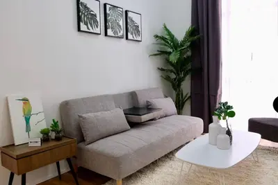a living room with a couch and a table at Golf Penthouse Balcony BGC in Manila