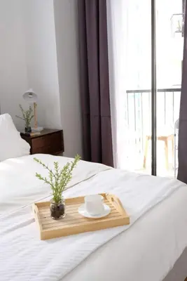 a tray with a cup and a plate on a bed at Golf Penthouse Balcony BGC in Manila