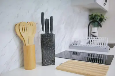 a kitchen counter with two wooden forks and knives at Julias Upscale Airy Getaway 1 BR Golf View in Manila
