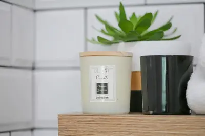 a candle sitting on a table next to a cup at Julias Upscale Airy Getaway 1 BR Golf View in Manila
