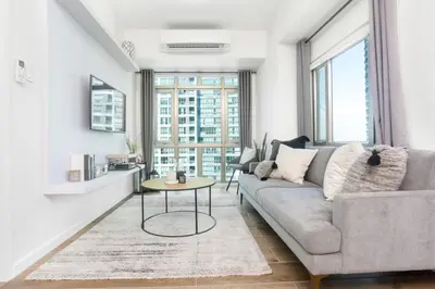 a living room with a couch and a table at Julias Upscale Airy Getaway 1 BR Golf View in Manila