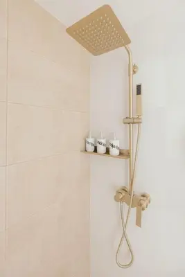a shower in a bathroom with white tiles at Modern Coastal Design 1 BR Condo Golf View BGC in Manila