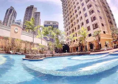 a large swimming pool in a city with tall buildings at Julias Contemporary Apt Balcony and Golf View in Manila