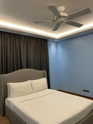 a bedroom with a bed with a ceiling fan at Solace Hotel in Manila