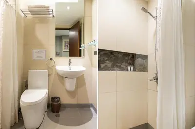 a bathroom with a toilet and a sink at Solace Hotel in Manila