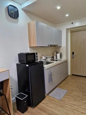 a kitchen with a black refrigerator and a microwave at Comfy Stay 50 mbps Wi-Fi, Smart TV, Netflix in Manila
