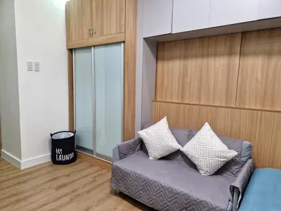 a living room with a couch with pillows on it at Comfy Stay 50 mbps Wi-Fi, Smart TV, Netflix in Manila