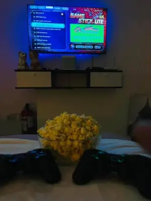 a bowl of popcorn sitting on a bed with a tv at Chelsea Tower by Calvin in Manila