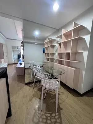 a dining room with a glass table and shelves at Chelsea Tower by Calvin in Manila