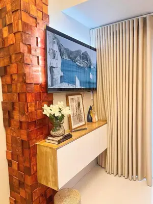a living room with a television on a brick wall at Chelsea Tower by Calvin in Manila