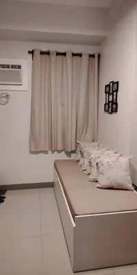 a bedroom with a bed with pillows and a window at 2BR Condo SMDC Charm Metro Manila in Manila